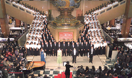 合唱団が中央ホールの「天女の像」を囲んで歌唱する（写真は過去の様子）。